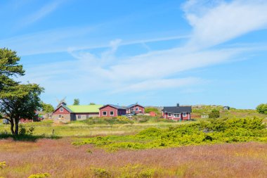 Fin balıkçı köyünün manzarası. Geleneksel ahşap evler, kayıkhaneler, rıhtımlar ve kuzey kırsalındaki huzurlu kıyı manzarası.