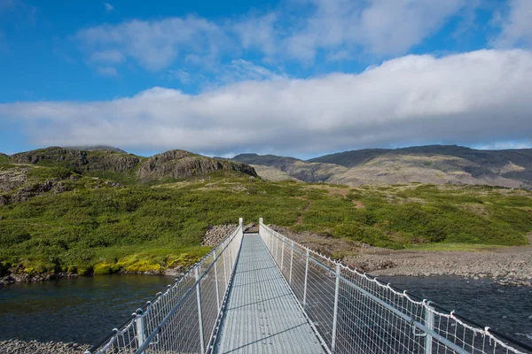 Walking bridge crossing river Kolgrafardalsa near nature resort of Haukafell in south Iceland