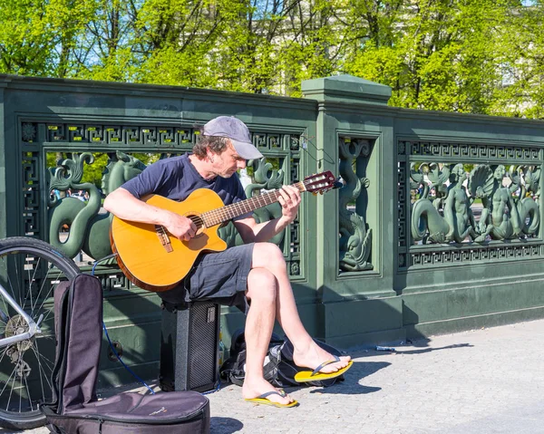 Man sitting on a bridge and playing guitar — Stock Photo, Image