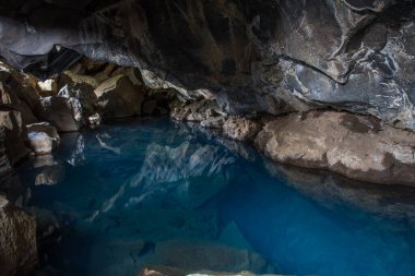 Grjotagja, Myvatn bölgesinde doğal jeotermal kaynak havuzu Kuzey İzlanda mavi suyu ve renkli lav taşları.