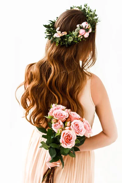 Çiçekli taçlı gelin arkasında güller taşıyor.