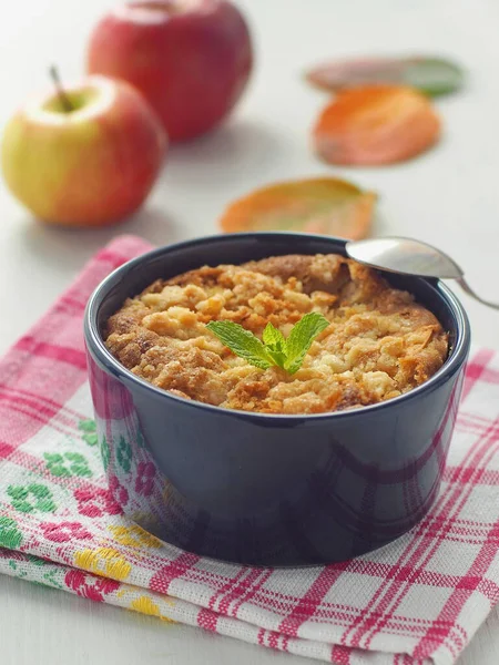 Close up of homemade cake portion served in a mug. Fresh crumble cake with apples. Vertical. Selective focus on the cake.