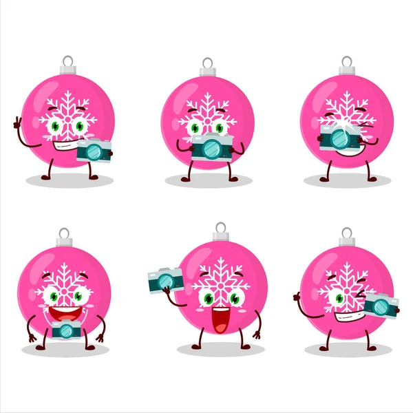 Fotógrafo profesión emoticono con bola de Navidad rosa personaje de dibujos animados — Vector de stock