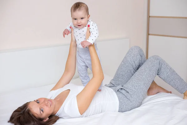 Jovem Mãe Está Brincando Com Seu Bebê Feliz Casa — Fotografia de Stock
