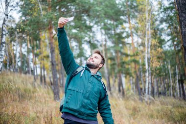 yakışıklı sakallı erkek turistik bir ormanda bir selfie alarak