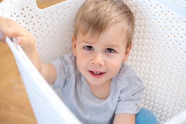 bir kutu içinde oturan ve oynarken iki yaşında bir çocuk