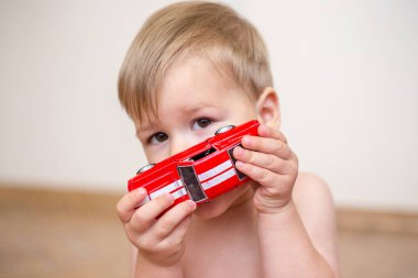 iki yıl yaşlı erkek çocuk kırmızı oyuncak araba ile oynuyor