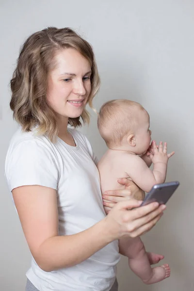 Madre Sosteniendo Bebé Mientras Usa Teléfono Inteligente — Foto de Stock