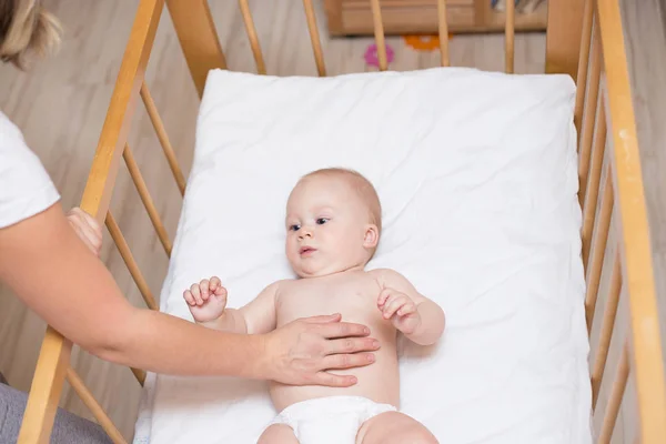 Madre Está Poniendo Bebé Una Cuna Para Dormir —  Fotos de Stock