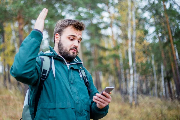Man checking map on phone while hiking in a forest