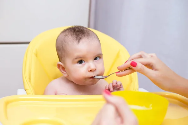 果物のピューレと彼女の赤ん坊の息子を送り 若い母親 — ストック写真