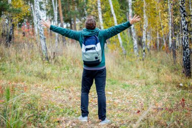 Mutlu erkek uzun yürüyüşe çıkan kimse başarı bir ormanda elinde yükseltti
