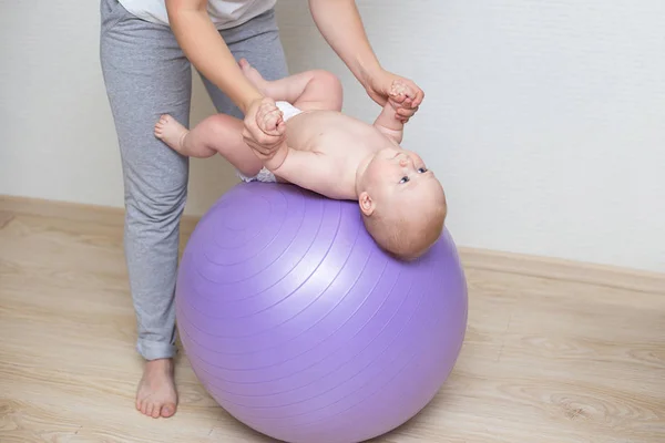 Anne ve bebeği bir topa birlikte yapıyor