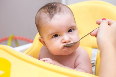 Genç anne bebek oğlu meyve püresi ile besleme