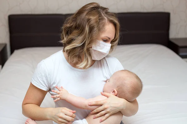Tıbbi maske onun hasta bebek çocuk tutan anne