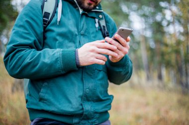 Harita üzerinde bir ormanda yürüyüş sırasında telefon kontrol adam