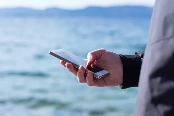 attractive guy is holding a smart phone and using it