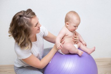 Anne ve bebeği bir topa birlikte yapıyor