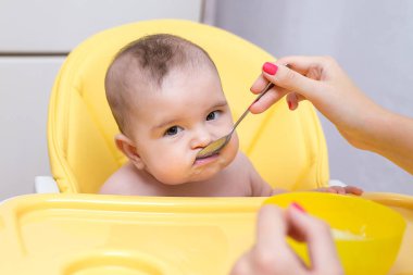 Genç anne bebek oğlu meyve püresi ile besleme