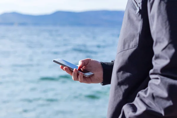 attractive guy is holding a smart phone and using it