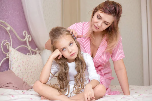 Loving mother consoling her sad and sulky daughter and trying to make peace