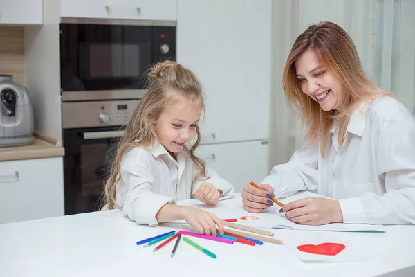 Anne ve kızı birlikte evde çizim. Mutlu bir aile