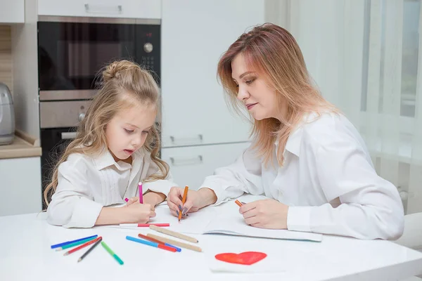 Anne ve kızı birlikte evde çizim. Mutlu bir aile