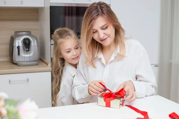 Kızın annesi Noel hediye evde oturma odasında veriyor.