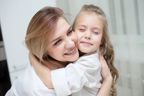Mutlu anne ve kızı evde birbirlerine sarılıyorlar