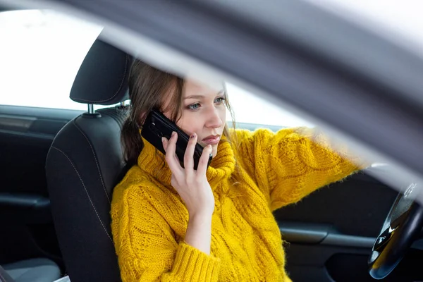 Femme parle sur son téléphone tout en conduisant une voiture Photos De Stock Libres De Droits