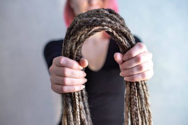 Bir kuaför dreadlocks ve pigtails tutuyor