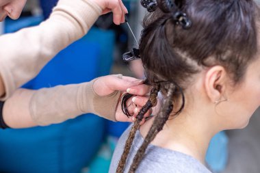 Kuaför bir kadın için dreadlocks veya pigtails dokuma
