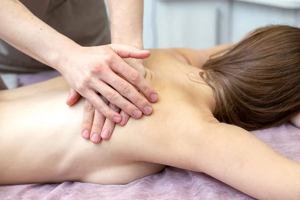 Belle jeune femme reçoit un massage dans un salon de massage — Photo