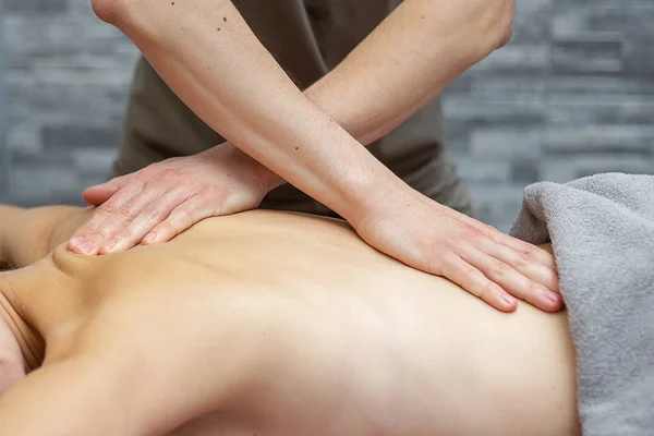 Un masseur masculin masse une femme dans un salon de beauté — Photo
