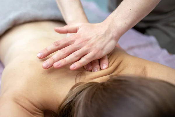 Bella giovane donna sta ricevendo un massaggio in un salone di massaggio — Foto Stock