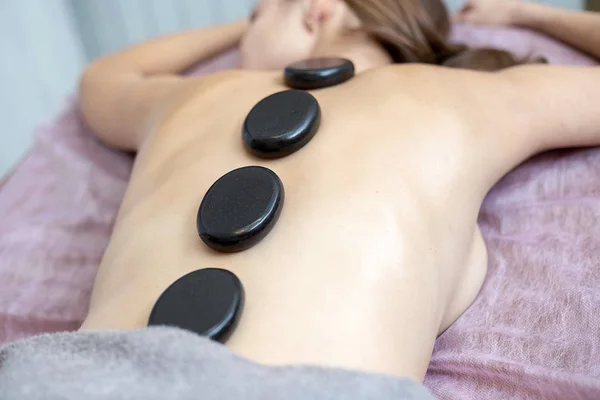 En kvinna får en Hot Stone massage på ett spa — Stockfoto