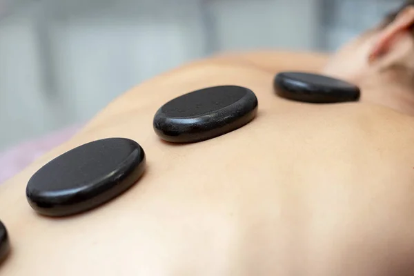 En kvinna får en Hot Stone massage på ett spa — Stockfoto