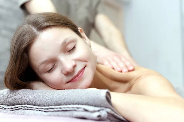 Bella giovane donna sta ricevendo un massaggio in un salone di massaggio — Foto Stock