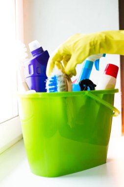Temizlik malzemeleri penceresinde ile plastik yeşil kova. Ev temizliği için donatım