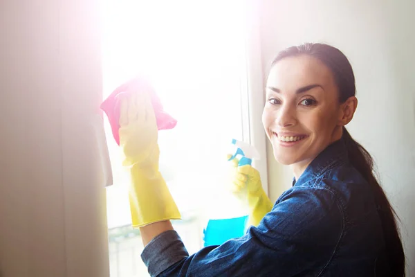 Hermosa Mujer Joven Usando Plumero Aerosol Mientras Limpia Ventanas Casa — Foto de Stock