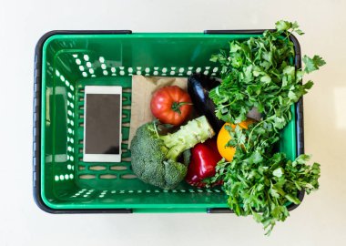 alışveriş sepeti içinde sebze ve smartphone ile üstten görünüm