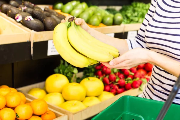 Женщина Держит Кучу Бананов Супермаркете — стоковое фото