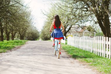 Genç kadın gündüz üzerinde bisiklete binmek dikiz
