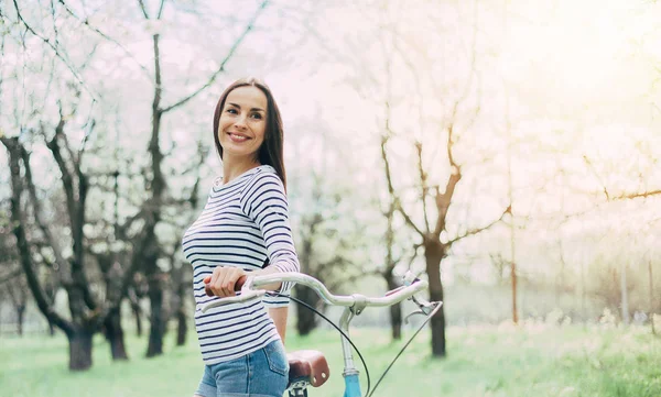 Sorrindo Jovem Mulher Com Bicicleta Fundo Jardim — Fotografia de Stock