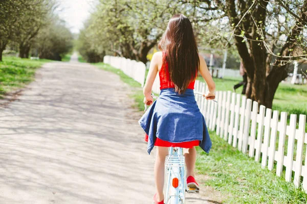 昼間の自転車に乗って若い女性の背面図 — ストック写真