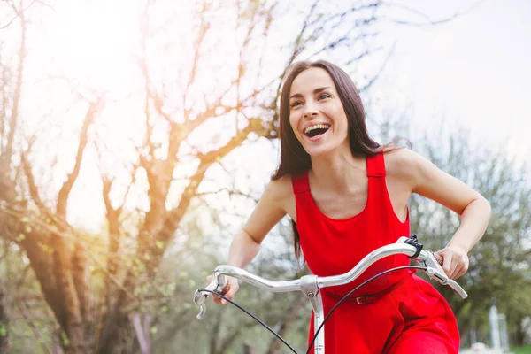 Sorrindo Jovem Mulher Vestido Vermelho Andando Bicicleta Durante Dia — Fotografia de Stock