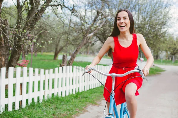 Sorrindo Jovem Mulher Vestido Vermelho Andando Bicicleta Durante Dia — Fotografia de Stock