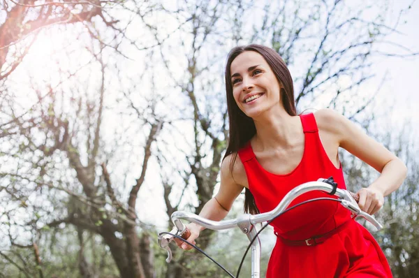 Sorrindo Jovem Mulher Vestido Vermelho Andando Bicicleta Durante Dia — Fotografia de Stock