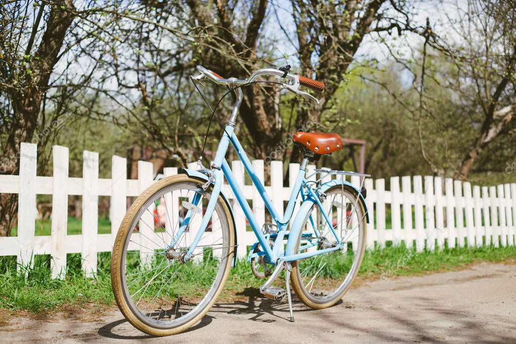blue bike standing on white fence background