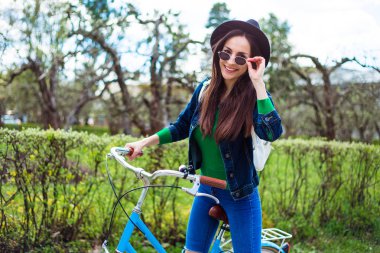 siyah şapkalı bisikletle poz genç kadın